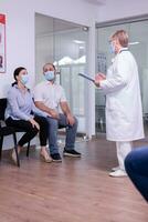 preoccupato giovane coppia indossare viso maschera contro infezione con coronavirus mentre in attesa notizia a partire dal medico. moglie di partenza per piangere dopo ricevente sfavorevole notizia a partire dal specialista medico, durante covid19. foto