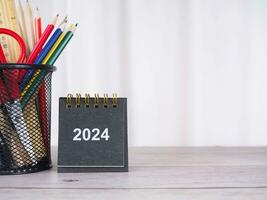 creativo scrivania con 2024 calendario e colorato Stazionario. copia spazio per testo, ufficio spazio di lavoro concetto. foto