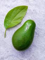 avocado fresco allestito su sfondo di pietra bianca. l'avocado è popolare per la cucina alimentare sana e il controllo del peso. foto