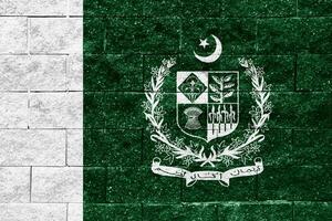 bandiera e cappotto di braccia di islamico repubblica di Pakistan su un' strutturato sfondo. concetto collage. foto