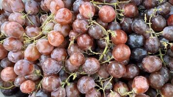 vicino su di crudo biologico dolce rosso uva sfondo, vino uva struttura, salutare frutta rosso vino uva sfondo, superiore Visualizza foto