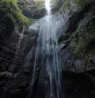 maestosa cascata che scorre su una scogliera rocciosa nella foresta pluviale tropicale foto