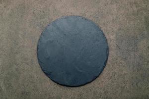 piatto vuoto per pizza per la cottura fatta in casa impostato su cemento scuro. ricetta alimentare concetto su pietra scura texture di sfondo con copia spazio. foto