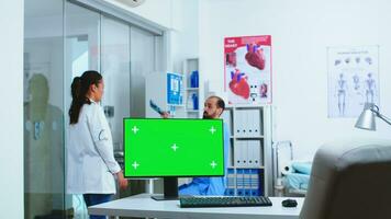 computer con verde schermo nel ospedale Consiglio dei ministri e medico controllo paziente raggi X. del desktop con sostituibile schermo nel medico clinica mentre medico è controllo paziente radiografia per diagnosticare. foto