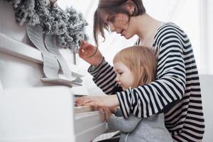 madre e figlia che suonano un pianoforte bianco, vista ravvicinata foto