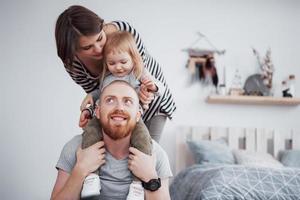 madre di famiglia felice, padre, figlia bambina a casa foto