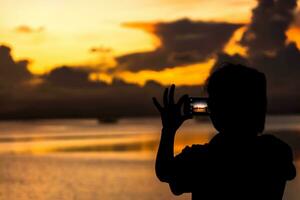 sagome persone tiro il tramonto a il lago. foto