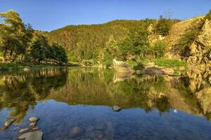 bellissimo riflessi nel il acqua di un' montagna fiume foto