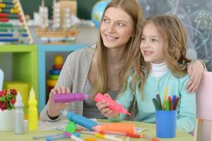 madre e poco ragazza pittura a casa foto