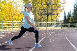 un' giovane bellissimo donna nel abbigliamento sportivo giochi gli sport a un' Locale stadio foto