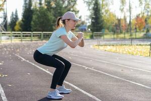 un' giovane bellissimo donna nel abbigliamento sportivo giochi gli sport a un' Locale stadio foto