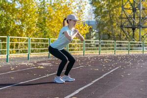 un' giovane bellissimo donna nel abbigliamento sportivo giochi gli sport a un' Locale stadio foto