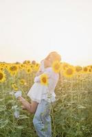 bella coppia che si diverte nei campi di girasoli foto