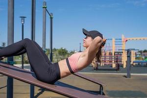 donna sportiva che si allena sul campo sportivo nella soleggiata giornata estiva foto