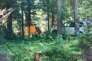 tenda gialla con auto suv nella foresta foto