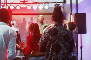 diverso persone discoteca su pista da ballo a dj prestazione festa nel discoteca. uomini e donne frequentatori di discoteche folla frequentando discoteca, danza e godendo vita notturna a musica Festival foto