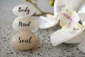 corpo, mente e anima testo inciso su bianca zen pietre meditazione e terme concetto foto