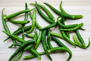 fresco verde chili Pepe su pianura di legno tavolo, verde essenziale verdure per tutti essenziale Alimenti, Visualizza di non pelati verdure con pianura sfondo foto