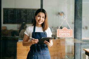 avviare riuscito piccolo attività commerciale proprietario pmi donna In piedi con tavoletta nel bar ristorante. donna barista foto