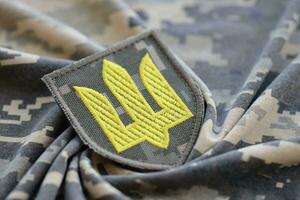 simbolo di ucraino esercito su il camuffare uniforme di un' ucraino soldato. il concetto di guerra nel Ucraina, patriottismo e proteggere il tuo nazione a partire dal occupanti foto