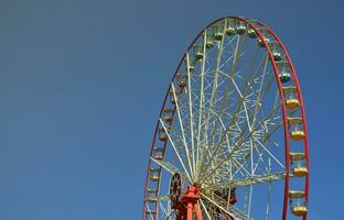 grande e moderno multicolore Ferris ruota su pulito blu cielo sfondo foto
