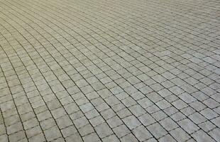 grigio colore pavimentazione lastre nel il pedone strada marciapiede. ruvido ciottolo modello con molti piazza sagomato pietre foto