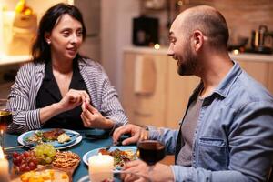 mostrando positivo gravidanza test per marito nel cucina mangiare cena. eccitato coppia sorridente, a ogni altro per Questo grande notizia. incinta, giovane moglie contento per risultato Abbracciare una persona uomo. foto