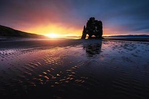 è una spettacolare roccia nel mare sulla costa settentrionale dell'Islanda. le leggende dicono che è un troll pietrificato. in questa foto hvitserkur si riflette nell'acqua del mare dopo il tramonto di mezzanotte