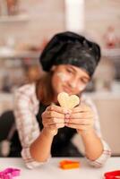 ritratto di sorridente ragazzo con grembiule Tenere tradizionale Impasto cucinando Pan di zenzero dolce nel natale culinario decorato cucina. nipote cottura al forno fatti in casa dolce a casa festeggiare Natale vacanza foto