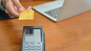 primo piano di clienti che pagano con carta di credito tramite edc. foto