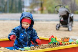 il bambino giochi macchine su il terreno di gioco foto