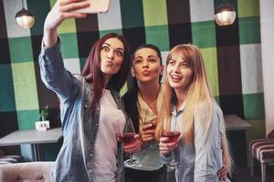 foto che presenta un gruppo felice di amici con vino rosso che si fa selfie