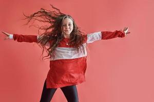 giovane donna urbana che balla su sfondo rosso, moderna e sottile ragazza adolescente in stile hip-hop