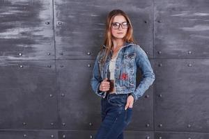 moda, abbigliamento, concetto di persone. attraente giovane donna sexy con giacca di jeans. la ragazza sta posando in studio foto