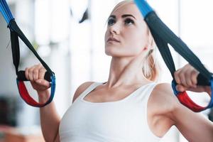 donne che fanno flessioni braccia di allenamento con cinghie fitness trx in palestra concetto allenamento stile di vita sano sport foto