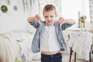 ragazzo indica il dito verso il basso. concetto di emozione. mostra il suo atteggiamento nei confronti delle lezioni e delle scuole foto