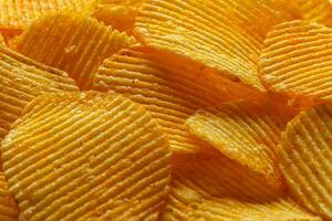 macro di bellissimo ondulato giallo patatine fritte sotto il di sole raggi foto