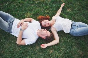 coppia allegra sdraiata sull'erba. giovani all'aperto. felicità e armonia.