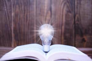 idea innovazione e concetto di ispirazione, lampadina illuminata sul libro, innovazione, brainstorming, ispirazione e concetti educativi. foto