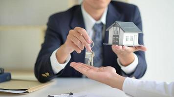 il broker di vendita della casa tiene le chiavi e la casa modello viene data ai clienti, concetto immobiliare. foto