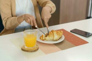 contento donna avendo prima colazione croccante Cornetti foto