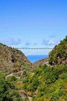 il ponte campate al di sopra di il oceano e il montagne foto