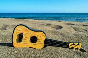 un' ukulele su il spiaggia foto