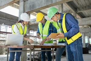 squadra di ingegnere, architetto, contraente e caposquadra incontro e consulenza a costruzione edificio luogo con pavimento Piano per vero tenuta sviluppo progetto industria e alloggiamento sequenza temporale foto