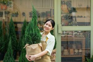 ritratto di asiatico donna Lavorando nel un' pianta negozio foto
