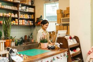 ritratto di asiatico donna Lavorando nel un' pianta negozio foto