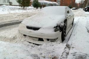 città strada nel inverno con un' auto sepolto nel neve dopo neve rimozione foto