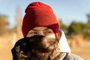 di mezza età donna nel rosso a maglia cappello copertura sua viso con capelli foto