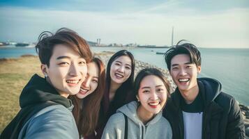 ai generato asiatico gruppo di amici sorridente in posa per foto. con blu cielo e natura sfondo. ai generato foto