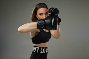 atletico donna nel boxe guanti è praticante karatè nel studio. foto